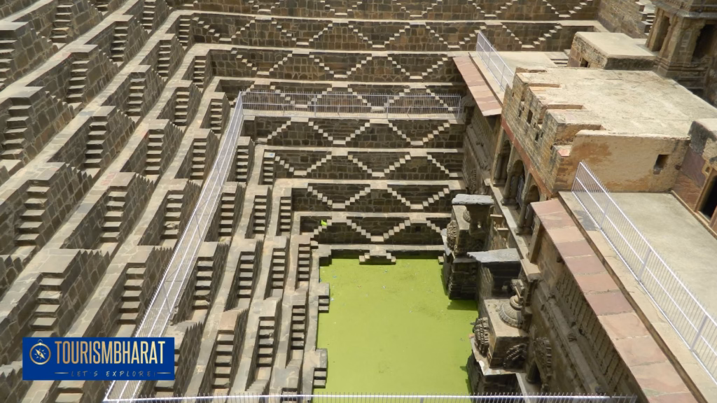 Chand Baori stepped well at Abhaneri with symmetrical staircases descending toward green water